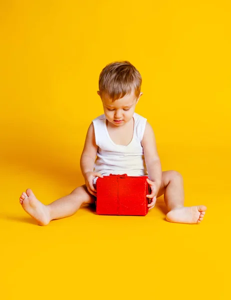 Bambino Siede Una Maglietta Mutande Accanto Una Confezione Regalo Rossa — Foto Stock