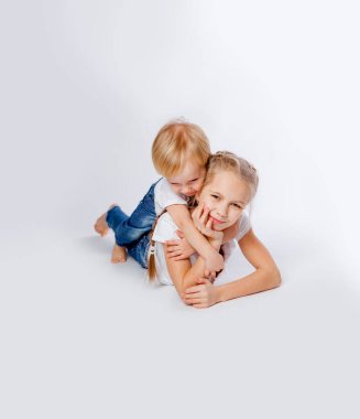 Kotlu ve tişörtlü ablalar sarılıyor.