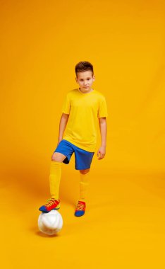 Futbol formalı bir çocuk sarı bir sırt grubunda