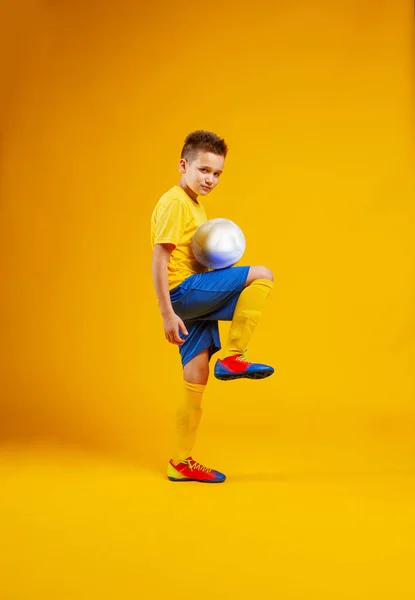 少年はスタジオでサッカーボールを — ストック写真