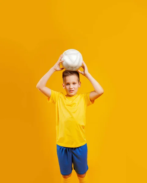 少年はスタジオでサッカーボールを — ストック写真