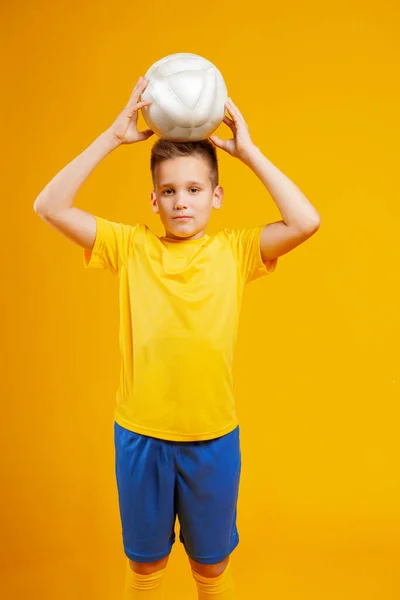 少年はスタジオでサッカーボールを — ストック写真
