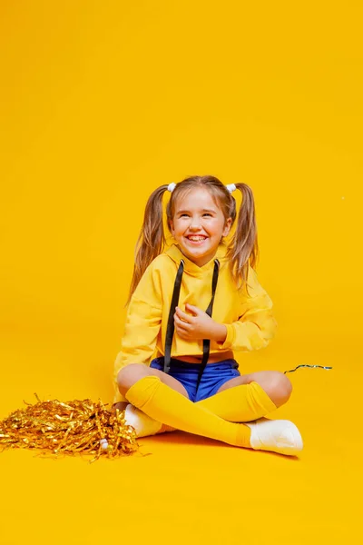 Χαριτωμένο Κορίτσι Μαζορέτα Ένα Κίτρινο Μπλουζάκι Και Μπλε Σορτς Κάθεται — Φωτογραφία Αρχείου