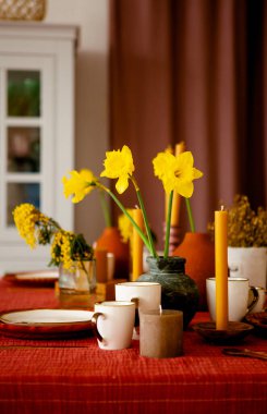 Mutfak masasındaki vazodaki nergisler.