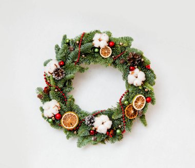 Noel çelengi, kırmızı parlak boncuklar, pamuk ve kurutulmuş portakal dilimleri.