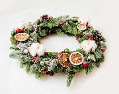 Kırmızı boncuklu Noel çelengi pamuk çiçekleri ve portakal dilimleri