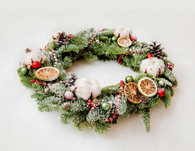 Kırmızı boncuklu Noel çelengi pamuk çiçekleri ve portakal dilimleri