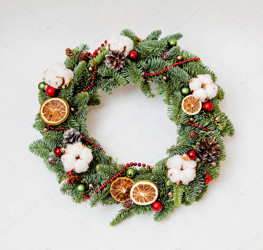 Christmas wreath with red shiny beads with cotton and slices of dried oranges