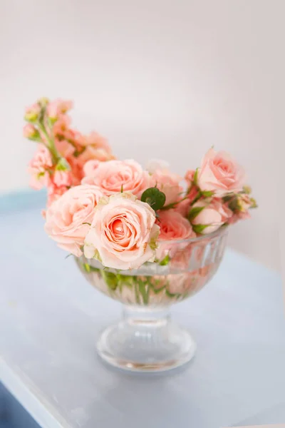 ヴィンテージスツールを背景にガラスの花瓶にピンクのバラ — ストック写真