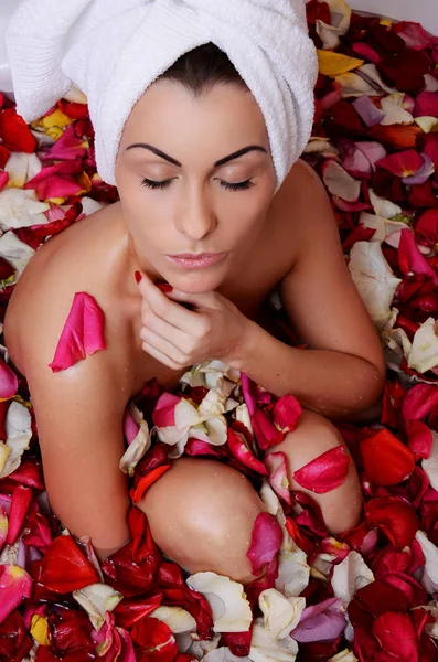 Gül yaprağı ile banyo güzel kadın. — Stok fotoğraf