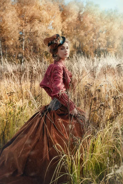 Γυναίκα σε ένα ιστορικά κοστούμι στο δάσος το φθινόπωρο. — Φωτογραφία Αρχείου