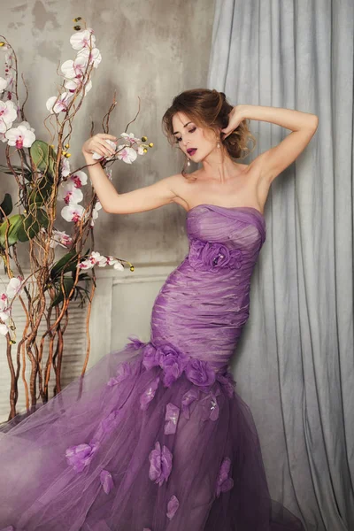 蘭の花を保持薄紫色のドレスの女性. ロイヤリティフリーのストック画像