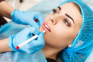 Kadının yüzünde kalıcı makyaj yapma güzellik uzmanı