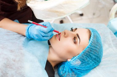 Kadının yüzünde kalıcı makyaj yapma güzellik uzmanı