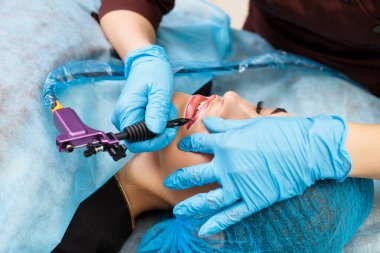 Kadının yüzünde kalıcı makyaj yapma güzellik uzmanı