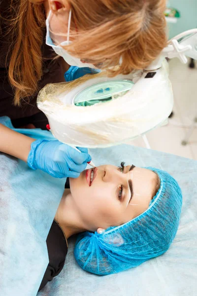 Cosmetólogo haciendo maquillaje permanente en la cara de la mujer —  Fotos de Stock