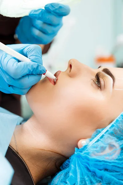 Cosmetólogo haciendo maquillaje permanente en la cara de la mujer —  Fotos de Stock