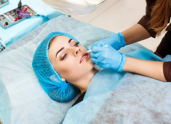 Cosmetologo rendendo permanente il trucco sul viso della donna — Foto Stock