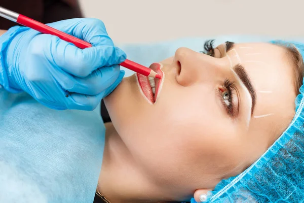 Cosmetologist making permanent makeup on woman's face — Stock Photo, Image