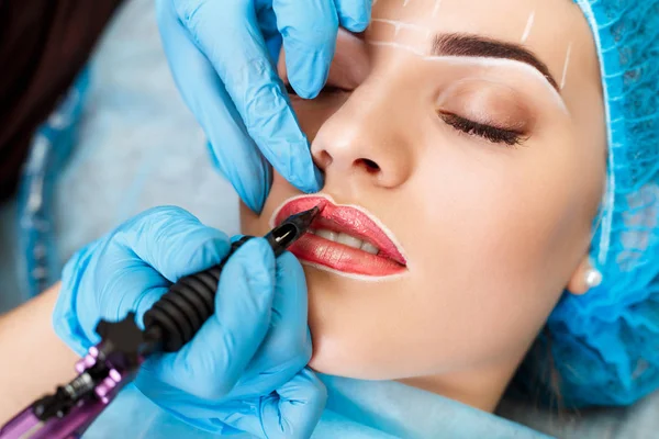 Cosmetologist making permanent makeup on woman's face — Stock Photo, Image