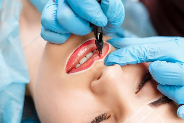 Косметолог делает постоянный макияж на лице женщины — стоковое фото