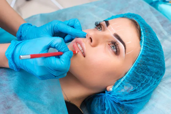 Kosmetolog att göra permanent makeup på kvinnans ansikte — Stockfoto