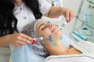Hasta prosedürü Darsonvald alır. Yüzünü ile jel sürülür.