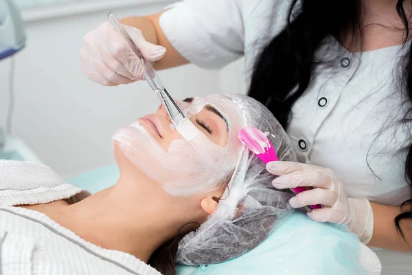 Mulher bonita com máscara facial no salão de beleza. — Fotografia de Stock