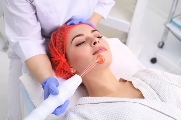 Ontvangende elektrische darsonval gezichtsmassage procedure. — Stockfoto