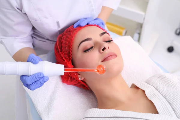 Ontvangende elektrische darsonval gezichtsmassage procedure. — Stockfoto