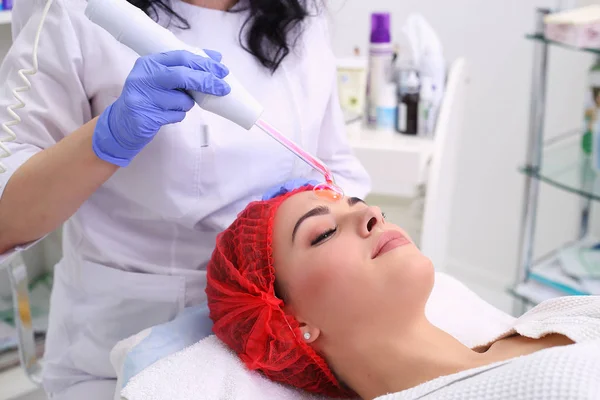 Ontvangende elektrische darsonval gezichtsmassage procedure. — Stockfoto