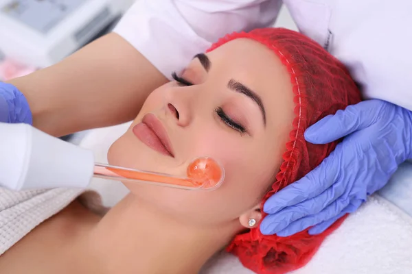 Recebendo procedimento de massagem facial darsonval elétrica . — Fotografia de Stock