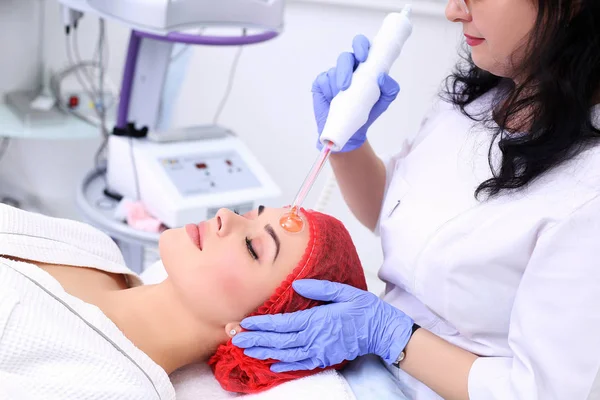 Recebendo procedimento de massagem facial darsonval elétrica . — Fotografia de Stock