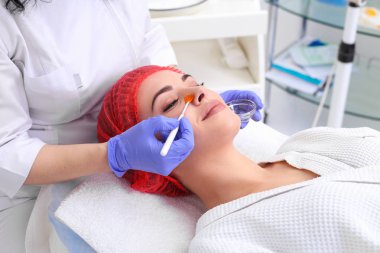 Güzel genç kadın yüz cilt tedavi görüyor.