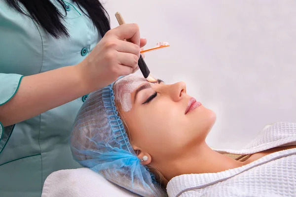 Mujer con máscara facial de arcilla en spa de belleza . —  Fotos de Stock