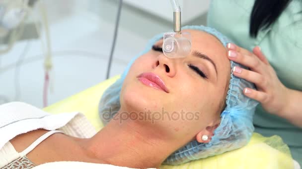 Receiving electric darsonval facial massage procedure. — Stock Video