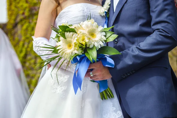 Las manos del novio y la novia con ramo de novia — Foto de Stock