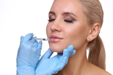 Güzel kadın bir enjeksiyon dudaklarını içinde alır.