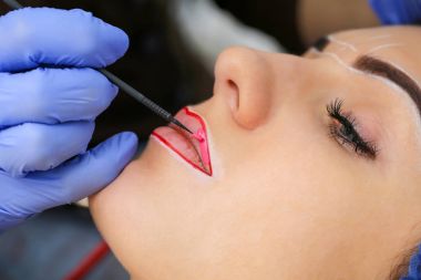 Kadının yüzünde kalıcı makyaj yapma güzellik uzmanı