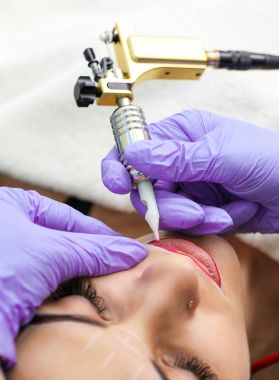 Kadının yüzünde kalıcı makyaj yapma güzellik uzmanı