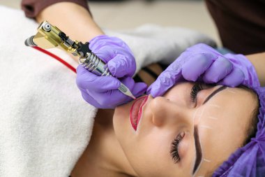 Kadının yüzünde kalıcı makyaj yapma güzellik uzmanı