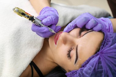 Kadının yüzünde kalıcı makyaj yapma güzellik uzmanı