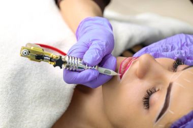 Kadının yüzünde kalıcı makyaj yapma güzellik uzmanı