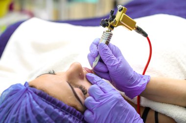 Kadının yüzünde kalıcı makyaj yapma güzellik uzmanı