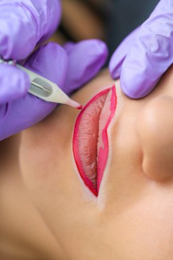 Kadının yüzünde kalıcı makyaj yapma güzellik uzmanı