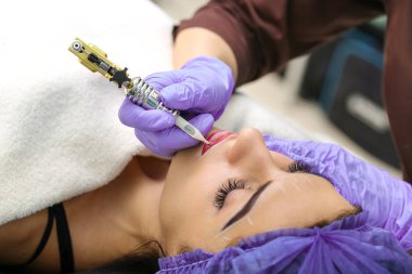 Kadının yüzünde kalıcı makyaj yapma güzellik uzmanı