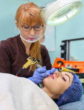 Kadının yüzünde kalıcı makyaj yapma güzellik uzmanı