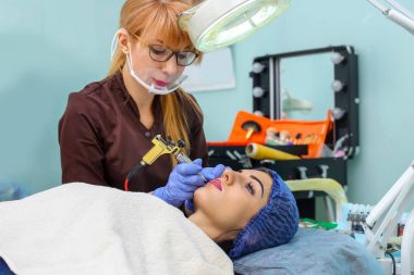 Kadının yüzünde kalıcı makyaj yapma güzellik uzmanı