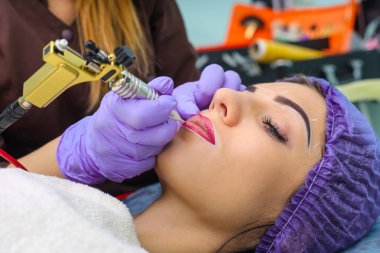 Kadının yüzünde kalıcı makyaj yapma güzellik uzmanı