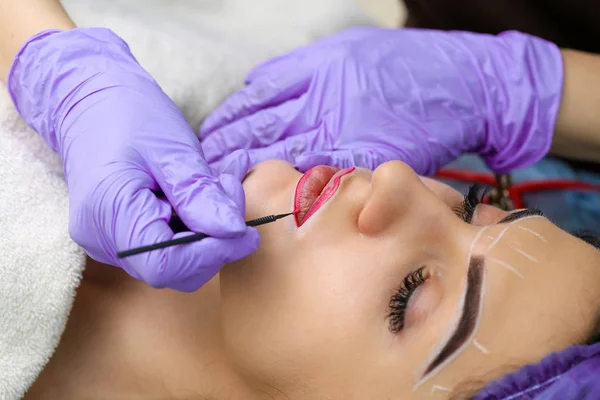 Cosmetologo rendendo permanente il trucco sul viso della donna — Foto Stock